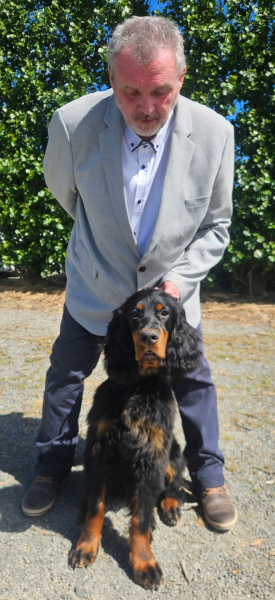 Ross wearing a suit and Mavrik the Gordon Setter puppy posing at a dog show