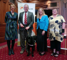 Andrea Midgen (CEO of BLVNZ), Clive Lansink (Board President of BLVNZ), Rt Hon Louise Upston (Minister of Disability Issues), Dr Chandra Harrison standing in front of the BLVNZ banner.