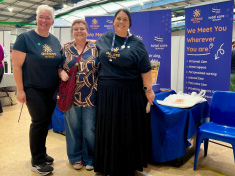 Chandra standing with Mel and Sure from Access Health in front of their stand at the Transitions Expo