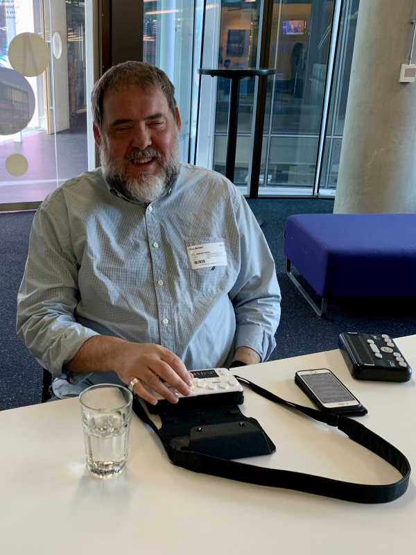 Man demonstrating a portal Braille device