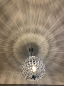 Ballroom style light fixture is throwing patterns on the ceiling. 