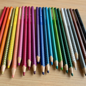 Coloured pencils lined up in a rainbow