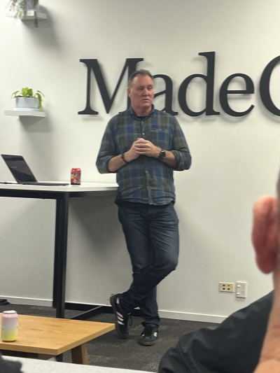 Steve Arnold standing casually answering questions from the auidence. He is standing in front of the MadeCurious sign.