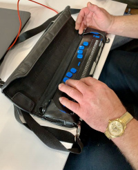 Someone sitting at a table with their hands visible using a Dynamic Braille Keyboard Braille in 2025.