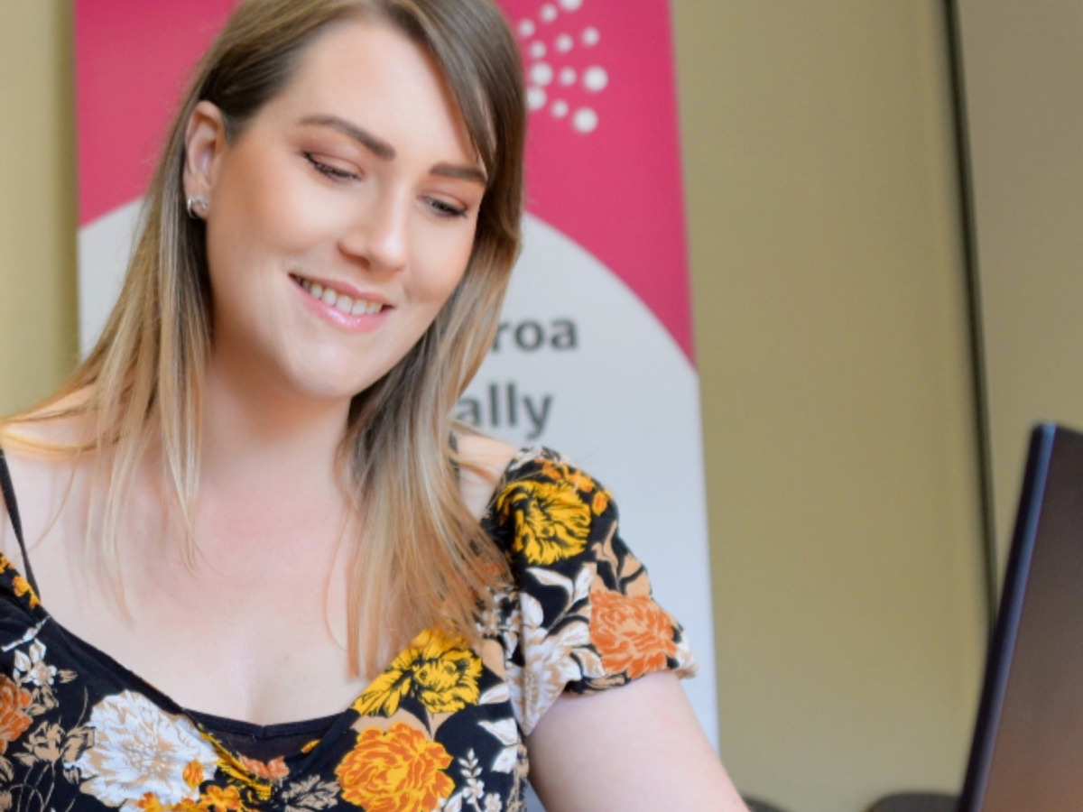 Kirsten smiling with the Access Advisors banner in the background