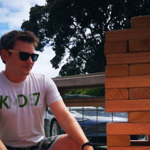 Eden outside playing jumbo jenga, wearing sunglasses