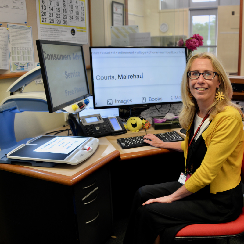 Kathy smiling at the camera from her workstation