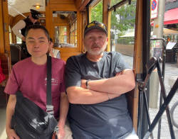 Ross and Julius riding the Christchurch Tram that Kevin drives. The scenery and interesting information is being audio described for Julius, who is blind, by the driver and Chandra as well