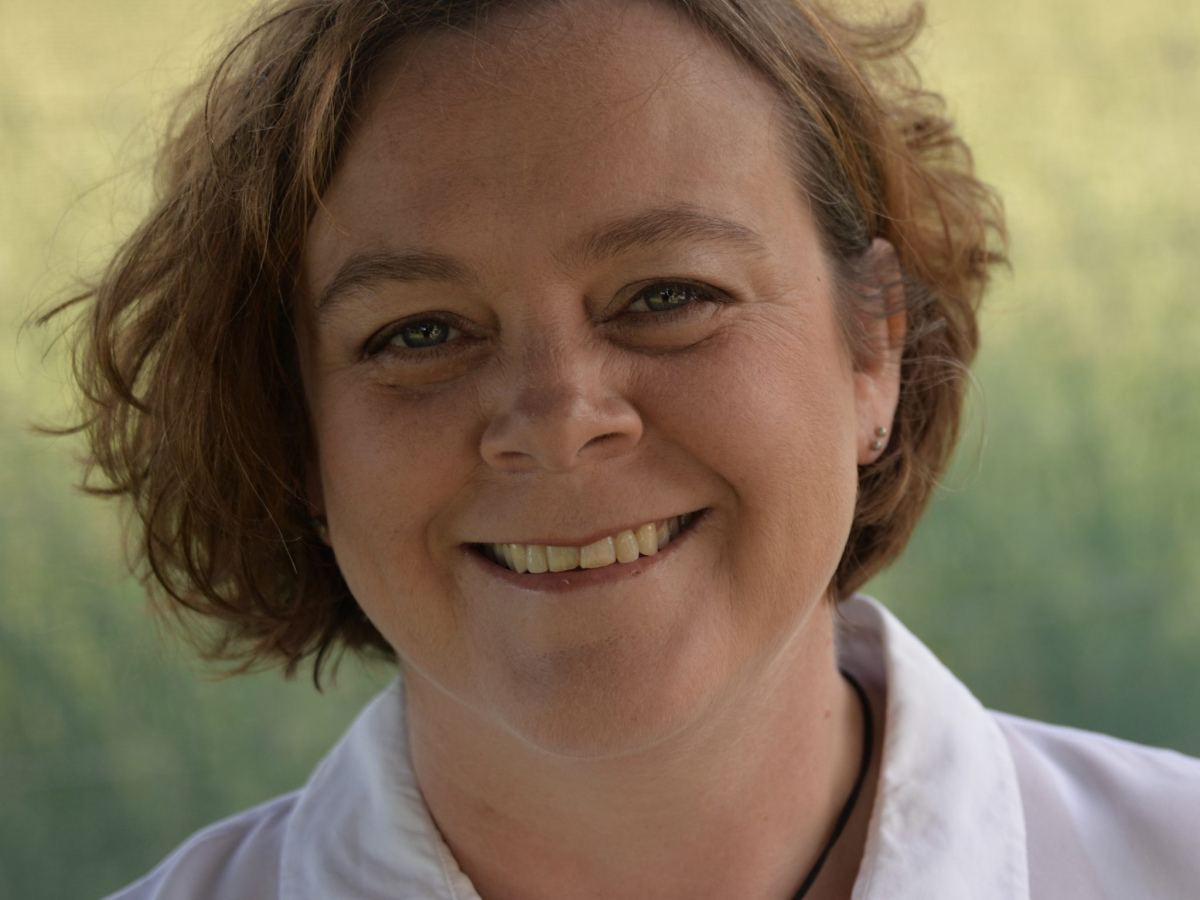 Dr Chandra Harrison headshot. She is smiling wearing a white shirt and a black necklace