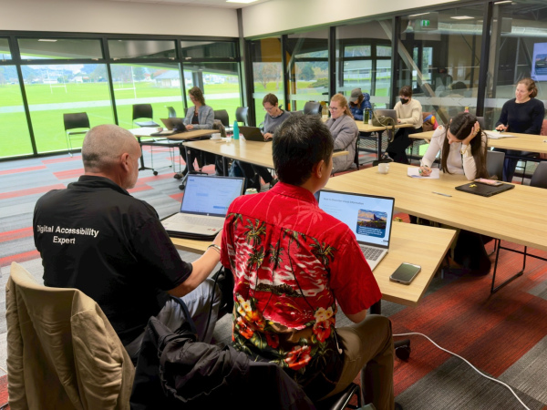 Ross and Julius presenting at our community training event in Wellington. Ross is wearing a black shirt with the words digital accessibility expert on the back and Julius is wearing a vibrant Hawaiian shirt.