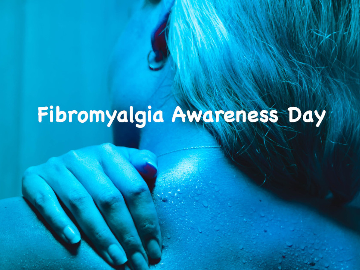 Fibromyalgia Awareness Day. A woman illuminated by blue light rubs her shoulder.