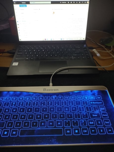 External glass keyboard plugged into a laptop