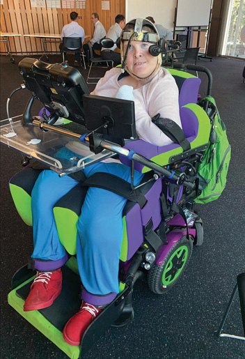 Meredith in her lime green and lilac chair, wearing her head wand.