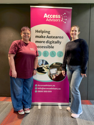 Chandra and Ciara standing either side of teh access Advisors pull up banner